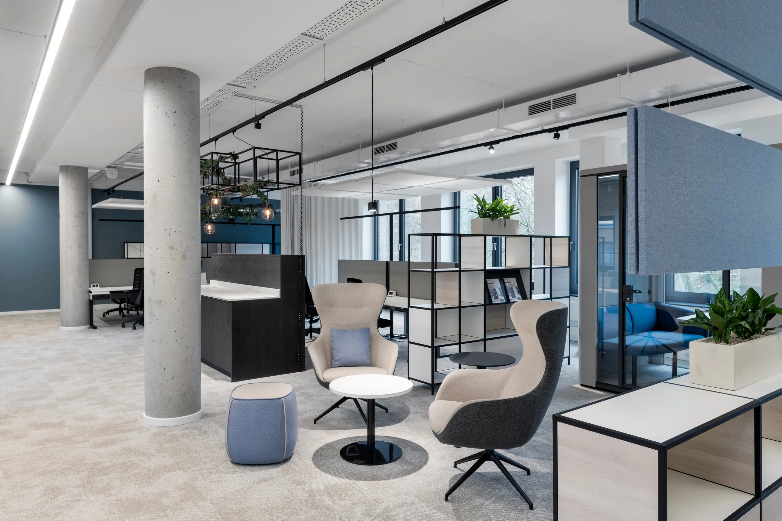 Moderne Bürolandschaft mit Loungesesseln, Akustikelementen und Arbeitsplätzen