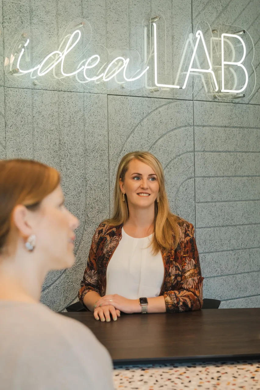 Gespräch im ideaLAB von Joppich & Rieckhoff vor der Leuchtschrift ideaLAB
